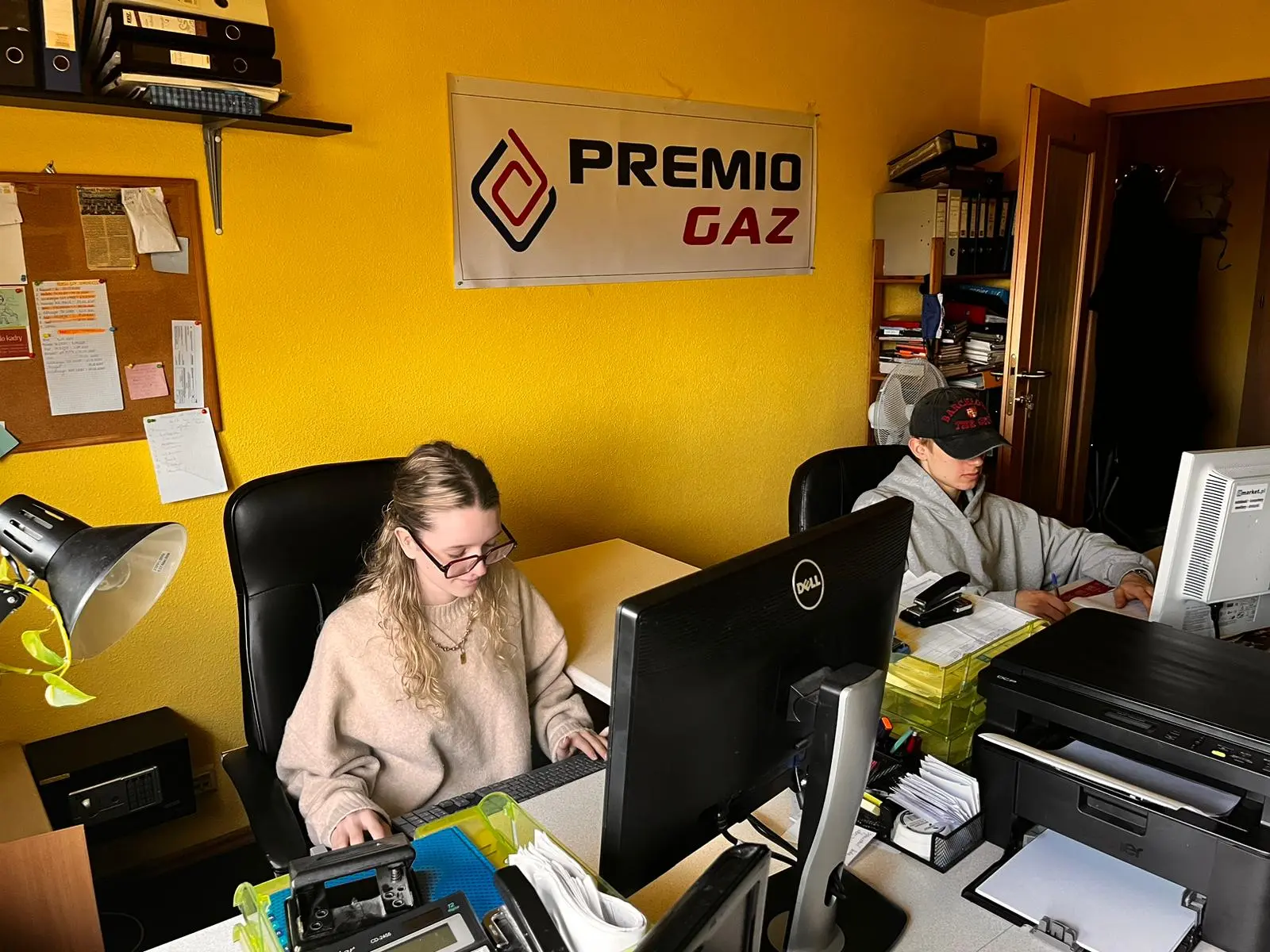 Butla z gazem z logo firmy PremioGaz na tle samochodu dostawczego.